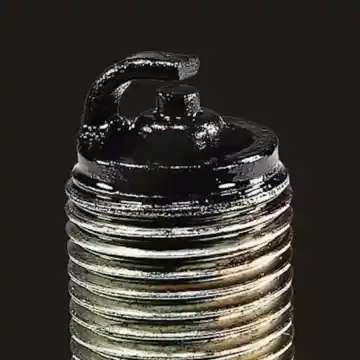 Spark plug covered in carbon deposits